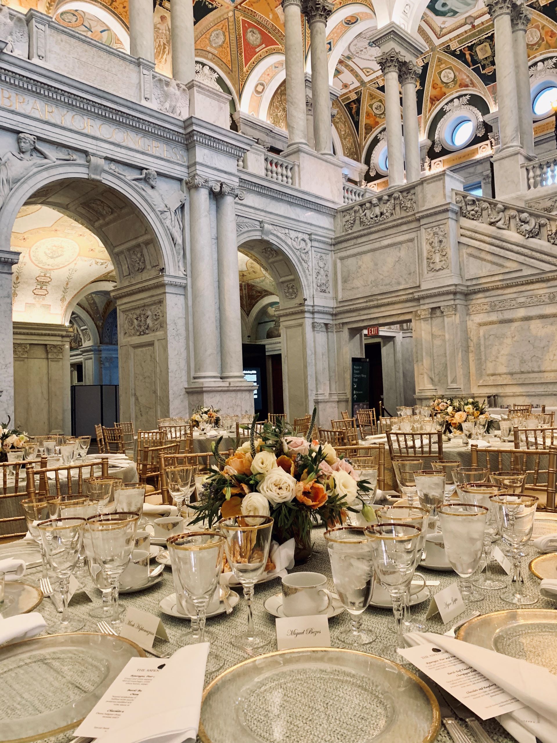catered event at library of congress by windows catering showing dishes and glasses and florals 
